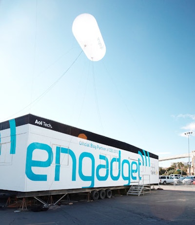 A tubular balloon hovered above Engadget's blue and white kiosk in the convention center parking lot.