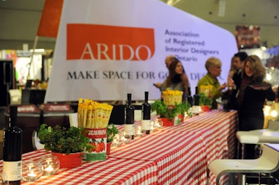 Potted herbs and tomato tins filled with GrissinBon bread sticks topped tables covered with red and white checkered linens in the main stage area.
