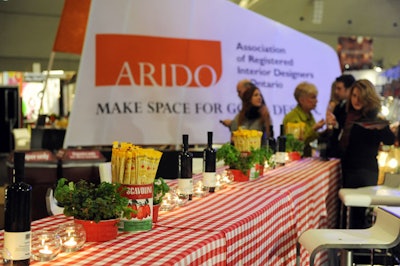 Potted herbs and tomato tins filled with GrissinBon bread sticks topped tables covered with red and white checkered linens in the main stage area.