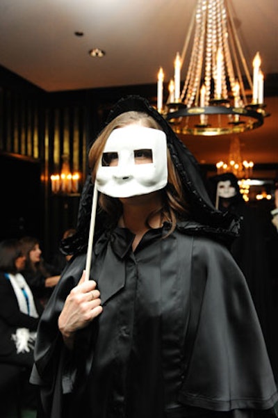 As the show began, cloaked figures holding Venetian masks formed a line down the runway while chimes played in the background.