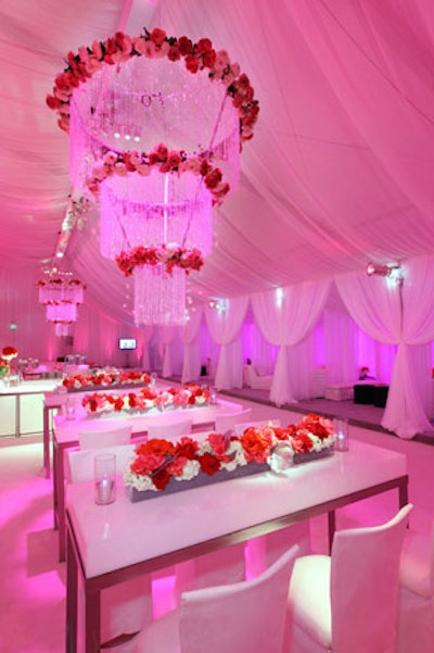 Long arrangements of multicolored roses topped white communal tables.