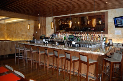 The rustic bar has reclaimed wood floors and stone walls.