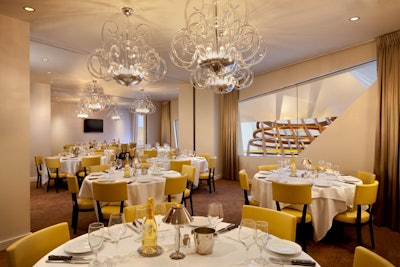 Clear glass chandeliers and yellow chairs create a clean look.