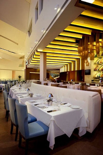 Curved white leather booths provide seating.