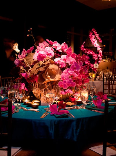 Lewis Miller Design contrasted a bold turquoise tablecloth with fuchsia orchids arranged in a large metal container.