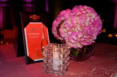Pink hydrangeas, votive candles, and a promotional flyer about the sparkling rosé topped each of the highboys.