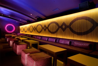 Plush has communal tiered seating and an antique gold metal mesh curtain.