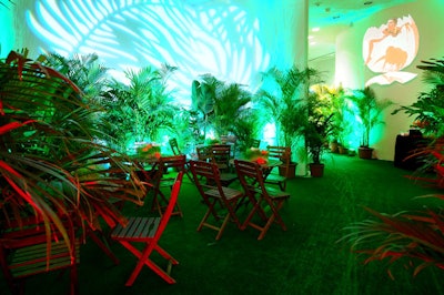 The Design Group of Miami used trees, patio furniture, and green lighting from All Access Audio Video Lighting to create an indoor garden at the far end of the museum.