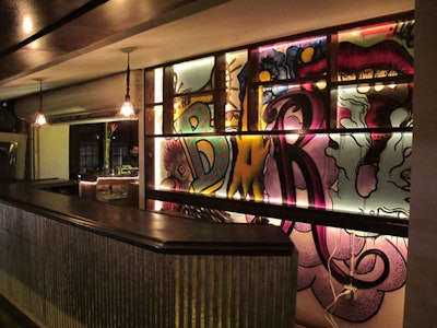 Artist Andres Risquez also painted the windows behind the main bar with a colorful street art-style mural.