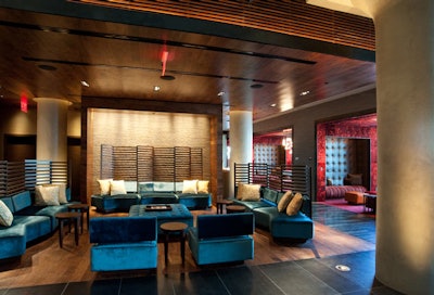 The hotel's lobby is decorated with textured stone walls, wooden screens, and custom furniture pieces.