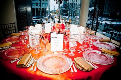 Red floral arrangements from Forget Me Not Flowers accented tables topped with paprika-coloured linens.
