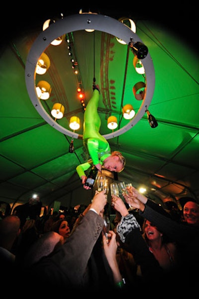 An aerialist served Perrier-Jouët Champagne while suspended beneath a chandelier in the middle of the BubbleQ tent.