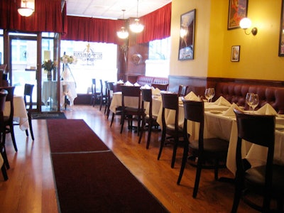 Cherry wood, yellow walls, and velvet drapes accent the 80-seat space.