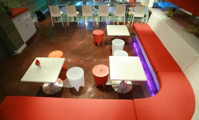 The mezzanine level has low banquettes, Philippe Starck stools, and adjustable stone-topped tables.