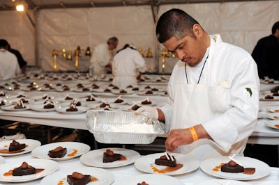 Led by chef Wayne Elias, staffers from Crumble Catering plated desserts in the kitchen.
