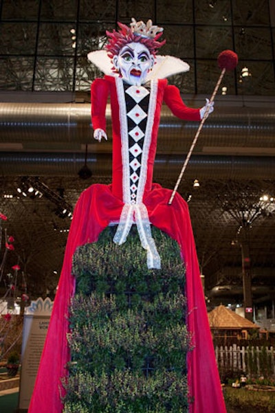 Flowering branches spring from the skirt of a towering Queen of Hearts statue in the storybook-inspired garden.