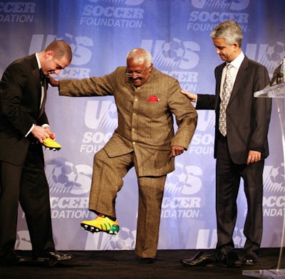 Antonio Zea of Adidas and Sunil Gulati of the U.S. Soccer Federation presented Archbishop Tutu with custom cleats that featured South Africa's colors and had his name engraved.