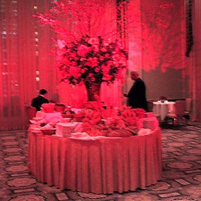A buffet table filled with breads, cheeses and vegetables was bathed in red light and topped with a giant bouquet.