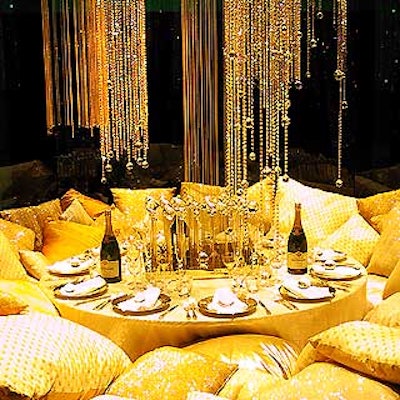 Avi Adler's Taittinger Champagne-sponsored table was golden luxe all the way, with shimmering strings of gold beads, a gold tablecloth, and Adler's signature centerpieces of grids of poles with globes on top. An inviting nest of pillows surrounding the table made for a sexy, alluring, glam display.