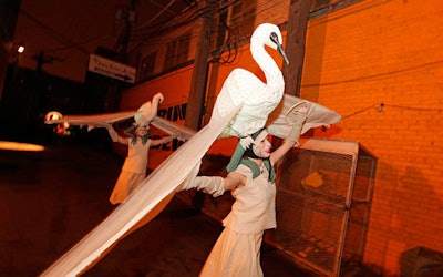 Performers in illuminated swan headdresses circulated in the alley leading to Redmooon Central.
