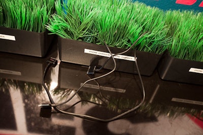 Power cords for iPhones sprout out of faux grass arrangements.