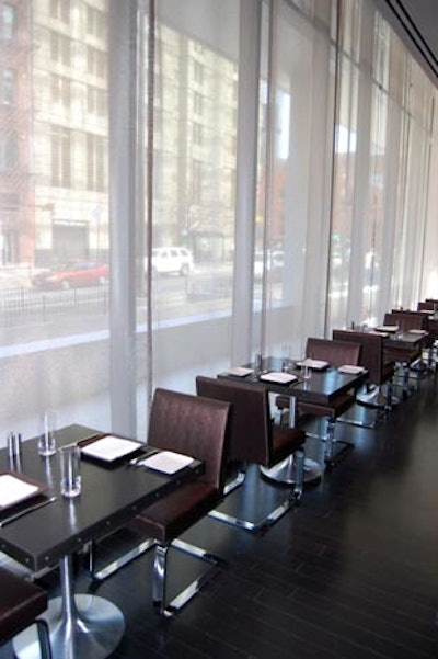 Two-top tables line windows that overlook a patio, set to open later this year.
