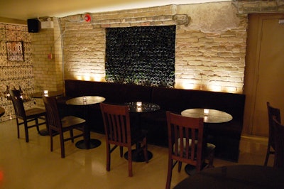 Rows of empty wine bottles fill a niche in the brick wall and serve as a focal point in the room.