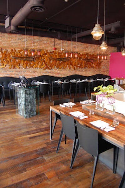 A sculpture created with wooden and metal socks hangs on an exposed brick wall in the dining room.