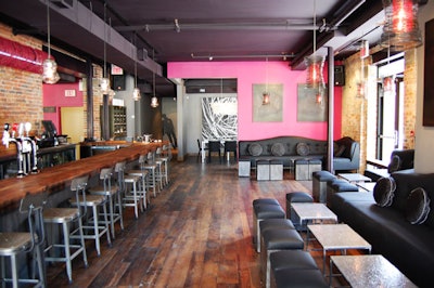 Black banquettes provide a relaxed seating area to the right of the bar.