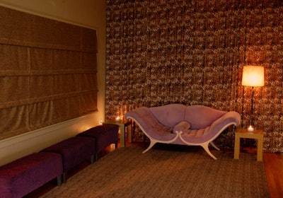 A funky purple sofa and multiple ottomans provide seating in the far corner of the cocktail room.