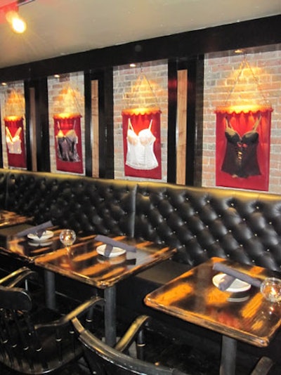 In addition to bar seating, black leather banquettes line one wall of the main dining room, accented by framed bustiers.