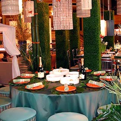 Eric Warner's Hunter Douglas picnic-like table featured woven wood lanterns and a centerpiece of shallow, round white dishes filled with water and decorated with faux butterflies. The plates were placed on top of big philodendron leaves.