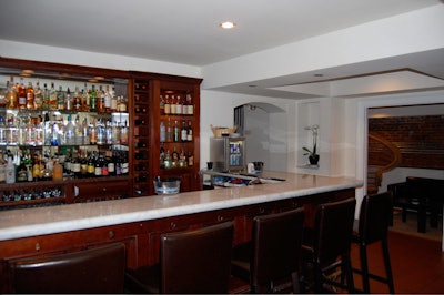 A small eight-seat bar with raw brick accents serves as the central space for the venue's multiple rooms.