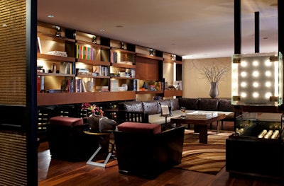 Overlooking the lobby and the street from its perch on the mezzanine level, the library lounge area is designed as a comfortable cocktail lounge.