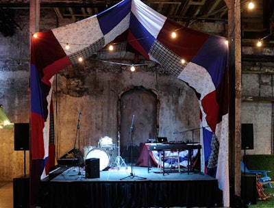 A patchwork tent, created by the volunteer committee out of fabric donated to Windfall, hung above the main stage.