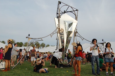 A mirrored art piece reflected the festival venue from multiple angles; water cascaded down its surfaces.
