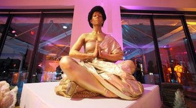 A gold-painted model from Cast of Thousands Entertainment struck a meditative Buddha pose at the after-party.