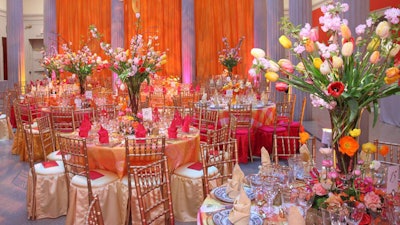 Floral arrangements and tabletops in the atrium had a pink, orange, and yellow color scheme, with blooming tulips and poppies in vases and a mix of plaid silk and sheer overlay linens.