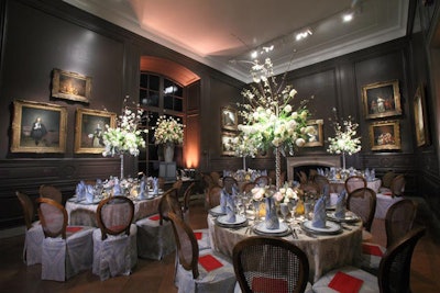 Traditional patterns were showcased in the Little Mantel Room, where cane-back chairs were fitted in cornflower blue chair skirts. Jack Lucky's white floral arrangements comprised cherry branches, Dusty Millers, white French tulips, cream lisianthus, and white garden roses.