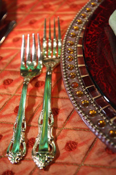 Red glass plates topped Copper Mosaic chargers in the Mantle Room, providing a stark contrasting to Jack Lucky's towering green bouquets.