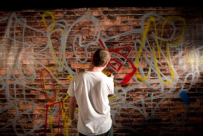 Throughout the four-hour party, graffiti artist Matthew Litwack tagged a mock brick wall with spray paint.