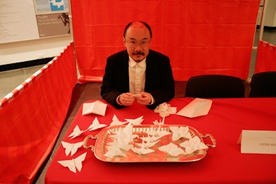 Carnival booths included games and toys, like one man making origami.