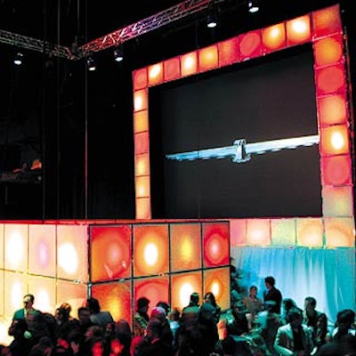 A rectangular box of paneled white Lucite stood in front of a large video screen that displayed runway images interspersed with the Thunderbird logo.