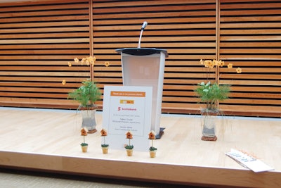 Birdhouses lined the stage, and orange flowers flanked the podium.