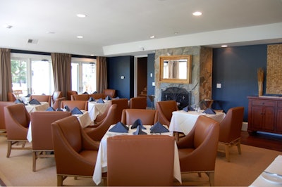 The 36-seat main dining room, with wood-burning fireplace, is furnished with brown leather chairs.