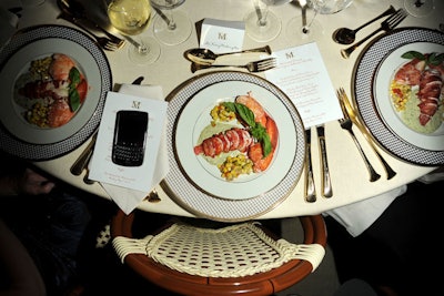 White porcelain pitchers with yellow parrot tulips—designed by Avila—served as centerpieces for the dinner tables, which were dressed with ivory-colored linen tablecloths and gold-trimmed china, and accompanied by wicker café chairs.