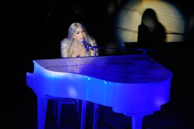 Lady Gaga's trademark white piano sat on stage during the dinner, an exception to the decor's theme of down-home simplicity. The singer skipped the red carpet to prep for her performance.