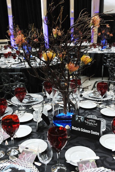 In the dining room, centrepieces featuring vases filled with bubbling blue water held arrangements of branches with pincushion protea flowers.