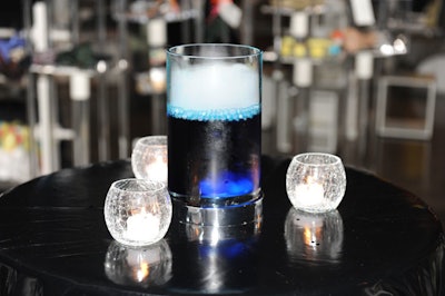 Vases filled with bubbling blue water topped cocktail tables throughout the party space.