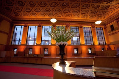 Event Creative placed towering white floral arrangements in the bank lobby. Guests passed through the space when heading to the basement, where the party took place.